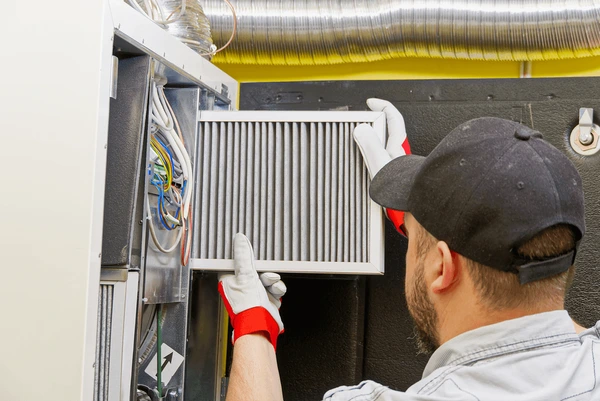 HVAC technician replacing furnace filter in Sterling Heights MI